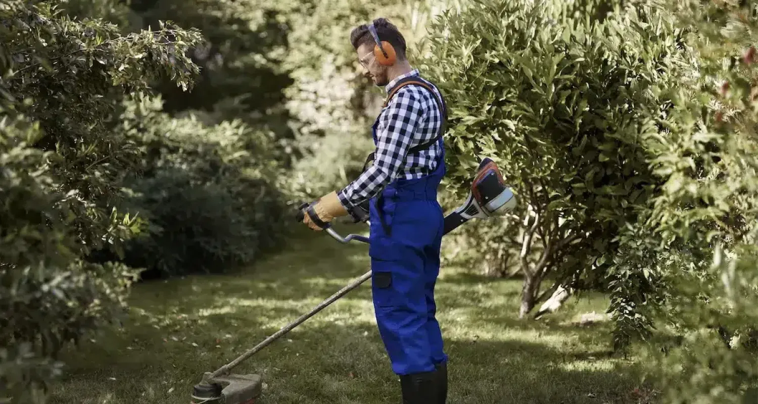 busy man using a weedwacker at garden min scaled 1 c7fc9124 Kadef Service